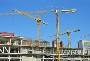 Crane and building construction site against blue sky