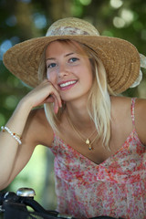 Blond girl with hat on a bike