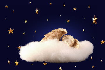 cherub sleeping on a cloud among the stars