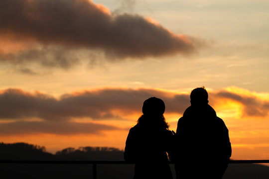 silhouette of couple watching sunset