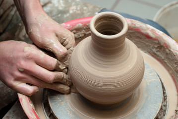 Fototapeta na wymiar hands of a potter, creating an earthen jar on the circle