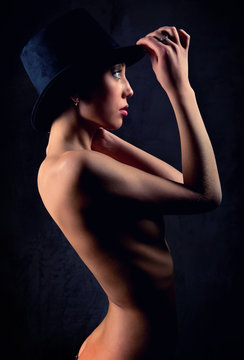 Beautiful woman wearing black hat posing indoors