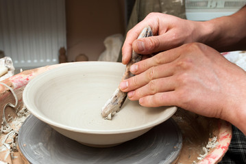 hands of a potter, creating an earthen jar on the circle