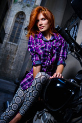 Plakat Sexy girl sitting on a motorcycle outdoors