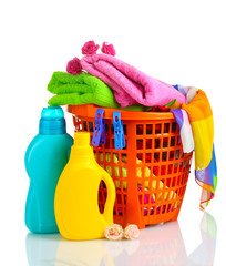 Clothes with detergent in orange plastic basket isolated