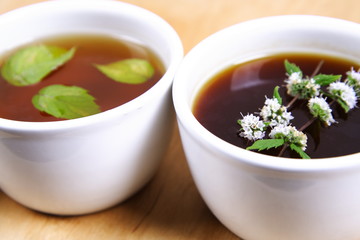 White Bowls of tea with mint leaves and twig