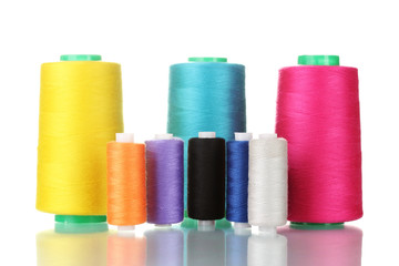Many-coloured bobbins of thread isolated on white