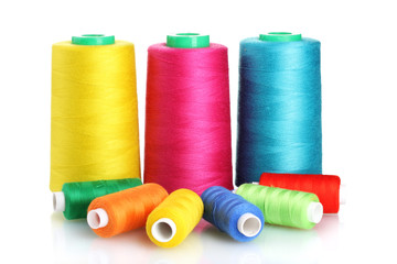 Many-coloured bobbins of thread isolated on white