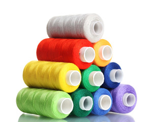 Pyramid of many-coloured bobbins of thread isolated on white