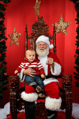 Fototapeta na wymiar Baby Boy Sitting on Santa's Lap