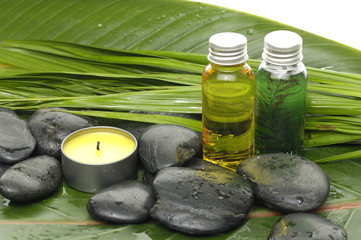 candle with stones on banana leaf background