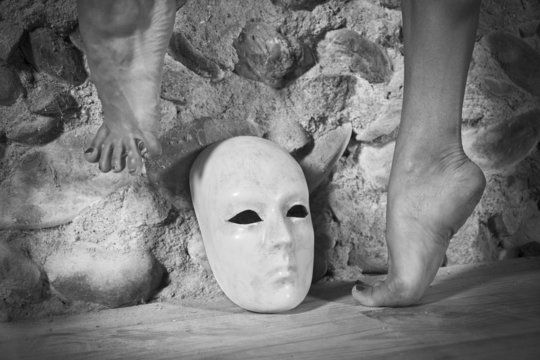 Pieds de danseuse au dessus d'un masque blanc