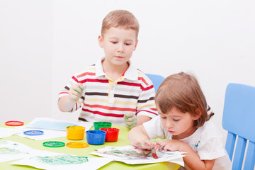 Fototapeta premium brother and the sister draw finger-type paints