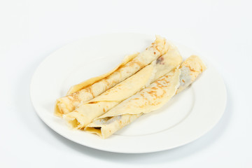 Rolled crepes (pancakes) on white plate