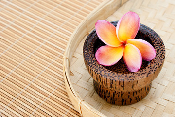 Fototapeta na wymiar Tropical Plumeria in wooden bowl for spa and wellness concept