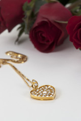 Heart pendant with diamond and red rose on white background