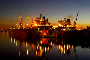 ship are being fixed and painted at the shipyard docks by night