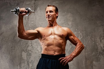 Handsome muscular man with dumbbell