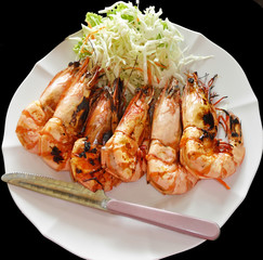 6 baked shrimp, arranged in a row on a plate dressed with a sala