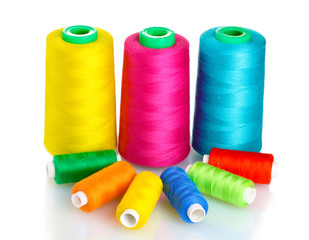 Many-coloured bobbins of thread isolated on white