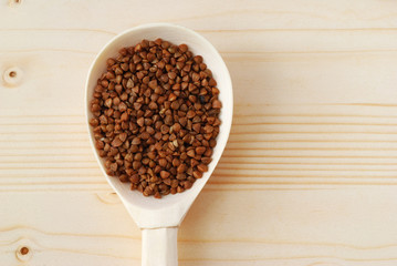 Buckwheat in the wooden spoon on the table