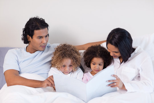 Parents reading a book with their children