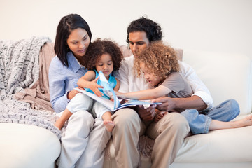 Family on the sofa looking at photo album together