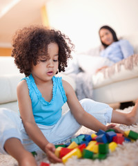 Girl in the living room playing with toy blocks