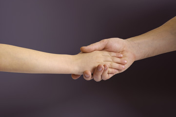 Father and child hands in the dark background