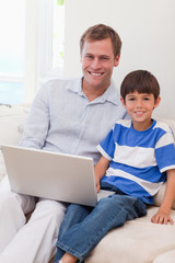 Smiling father and son surfing the internet together