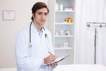 Male doctor with clipboard and pen