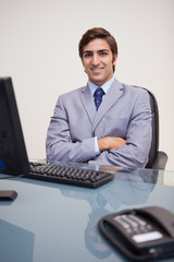 Businessman with folded arms leaning back satisfied