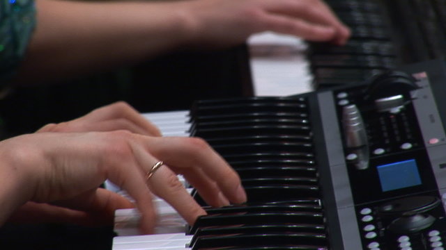 woman's hands playing a keyboard