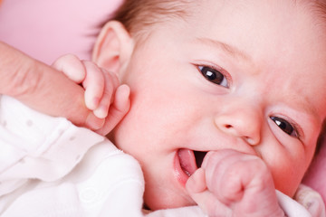 Baby girl holding her mother's finger