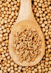 Soy flakes in wooden spoon