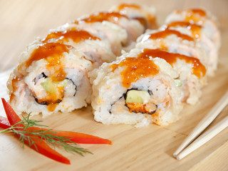 sushi roll with sauce on wooden board. close up food photo