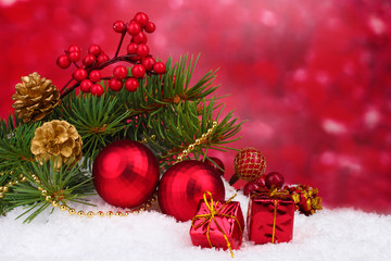 Christmas ball and green tree in the snow on red