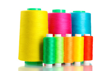 Many-coloured bobbins of thread isolated on white