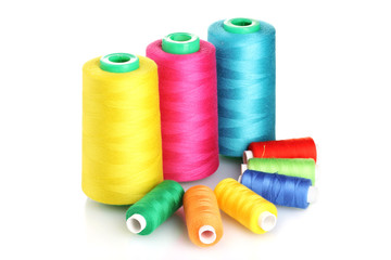 Many-coloured bobbins of thread isolated on white