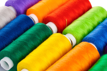 Many-coloured bobbins of thread closeup