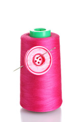 Pink bobbin thread with needle and pink button isolated on white