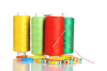 Many bobbin of thread with needle and buttons isolated on white