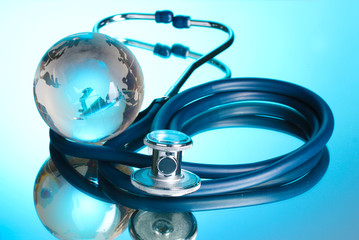 Globe and stethoscope on blue.