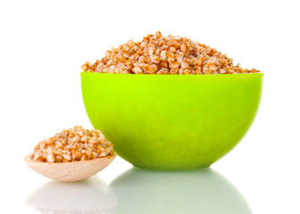 Boiled buckwheat in a green bowl isolated on white