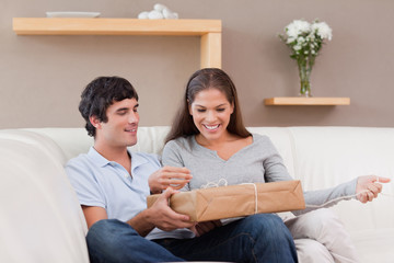 Obraz premium Couple opening parcel on the sofa