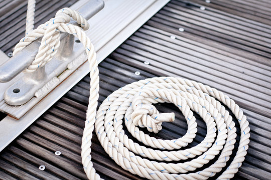 Fototapeta Mooring rope with a knotted end tied around a cleat.