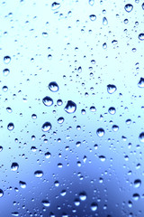 Beautiful abstraction with water drops over blue glass backgroun