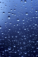 Beautiful abstraction with water drops over blue glass backgroun
