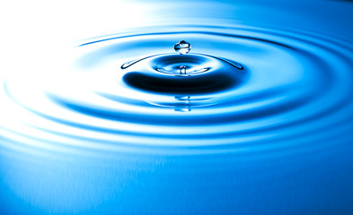 Transparent drop of water, falls downwards.