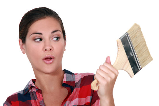 A Female Painter Looking At A Brush With A Dubious Look.